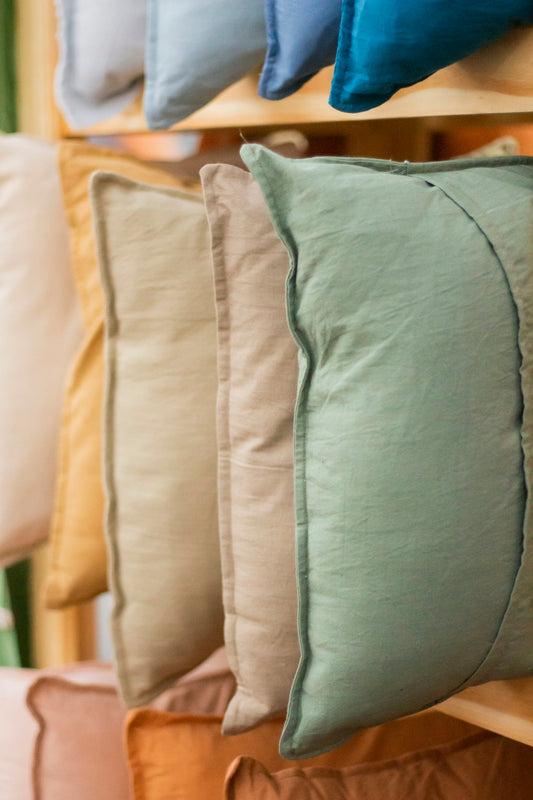 a row of pillows sitting on top of a wooden shelf