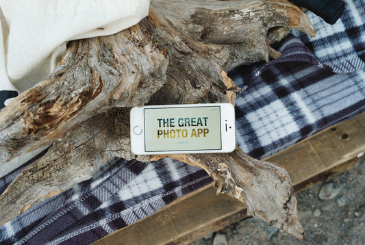 a cell phone sitting on top of a piece of wood