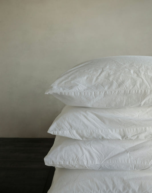 a stack of pillows sitting on top of a wooden table