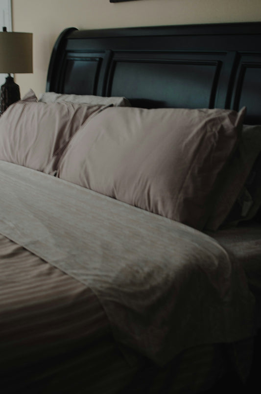 a bed with a brown comforter and pillows