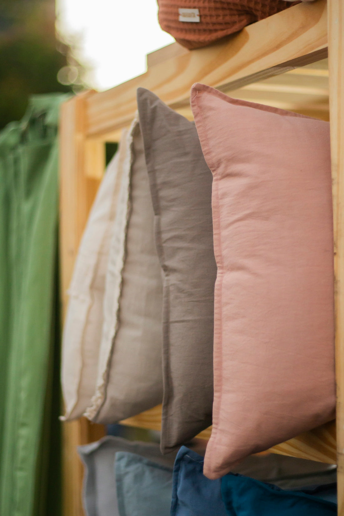 a row of pillows sitting on top of a wooden shelf