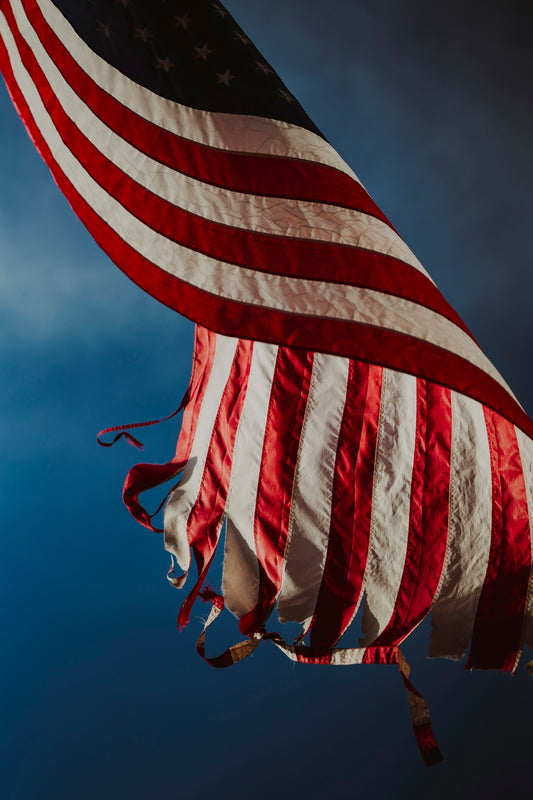 A large american flag flying in the sky