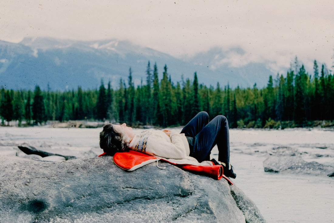 A woman laying on top of a large rock