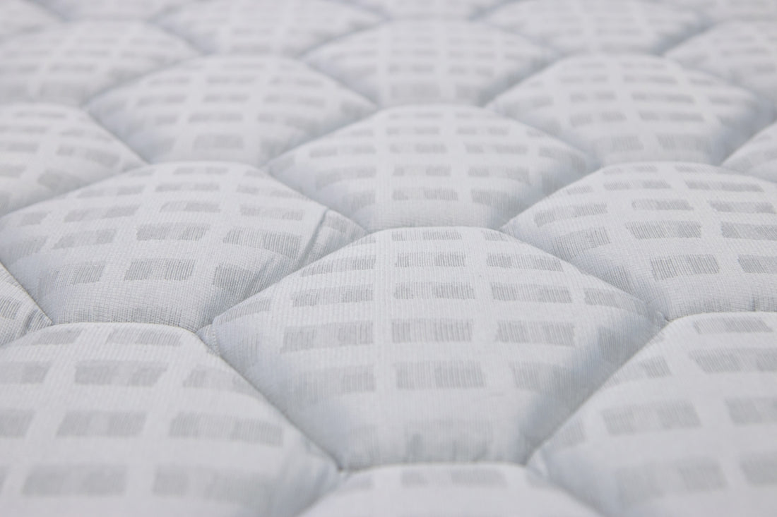 Close-up of a white quilted mattress texture