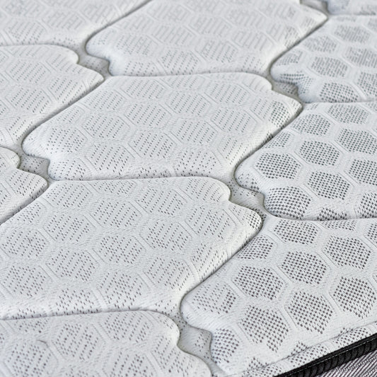 Close-up of a quilted mattress surface with hexagonal pattern.