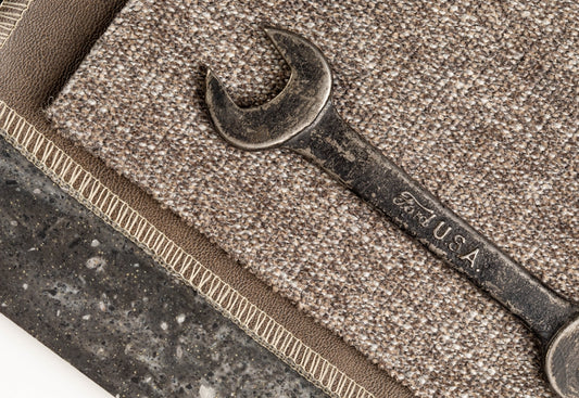 Wrench resting on carpet and stone samples.