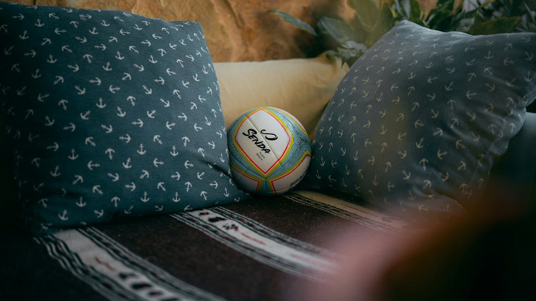 Decorative ball nestled between blue patterned pillows